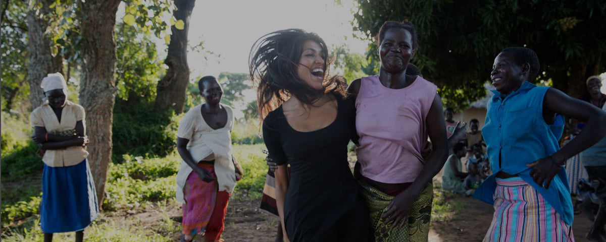Leila Janah dancing with female producers in Uganda